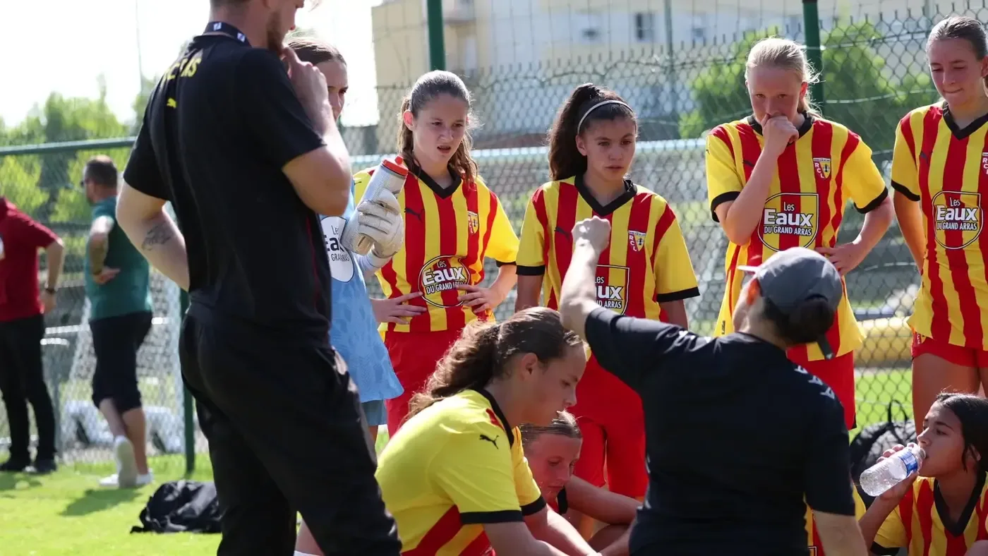 A coach briefing seated players before a session