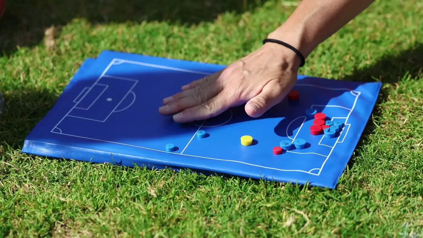 A coach's tactics board on the grass